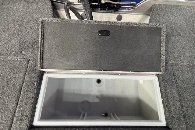 Slide: The Image of Open storage compartment in 2026 Crestliner 1650 Hawk boat, featuring carpeted interior. - 8