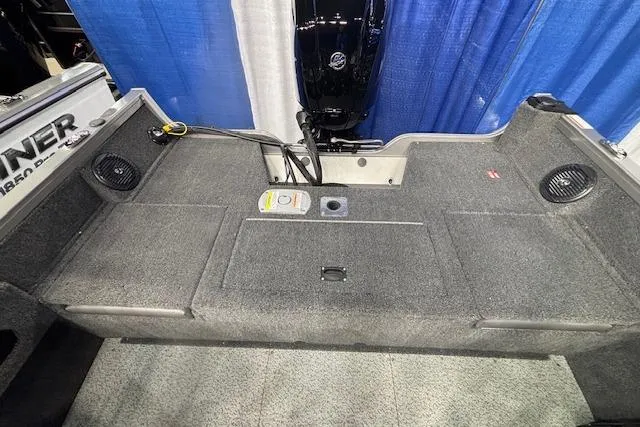 Slide: The Image of 2026 Crestliner 1650 Hawk boat interior with carpeted deck and motor, showcased at an event. - 9