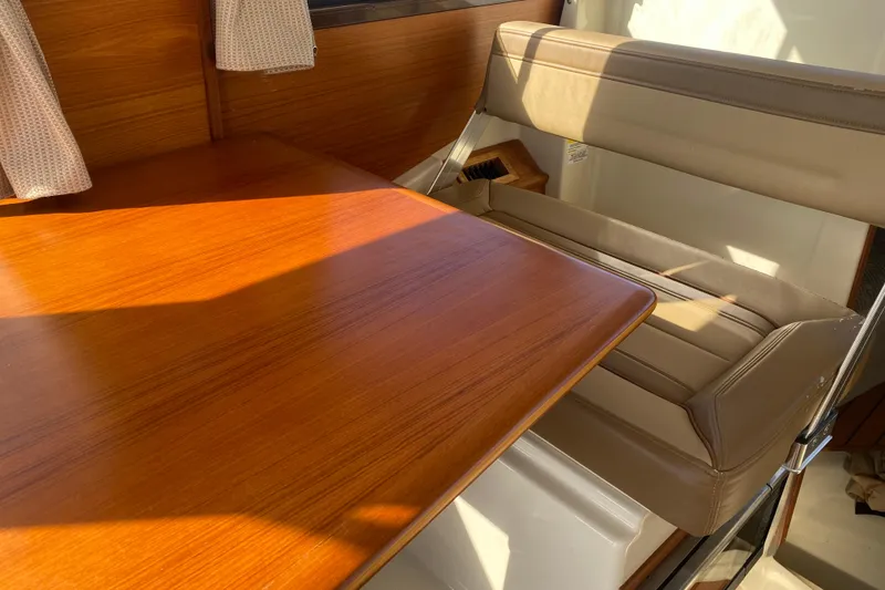 Slide: The Image of Interior of 2020 Ranger Tugs R-23, featuring a wooden table and cushioned seating. - 2