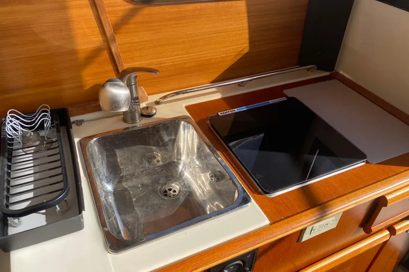 Slide: The Image of 2020 Ranger Tugs R-23 boat kitchen with sink, faucet, and cutting board. - 6