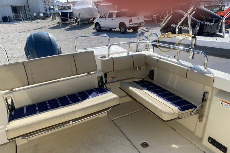 Slide: The Image of 2020 Ranger Tugs R-23 boat interior with cushioned seating and outdoor motor view. - 8
