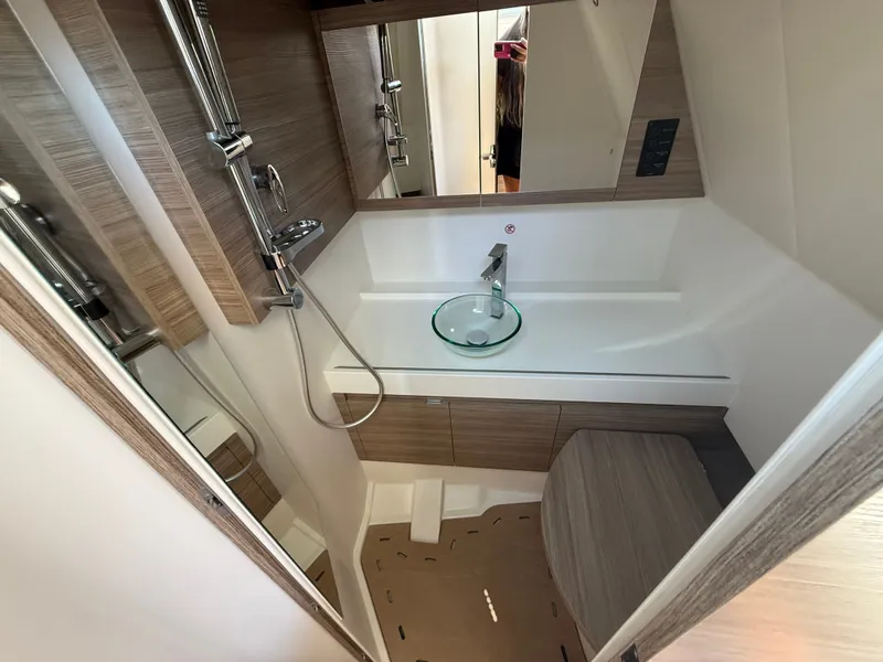 Slide: The Image of The image shows a modern boat bathroom with wood paneling and a glass sink. - 21