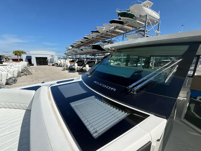 Slide: The Image of A 2027 Saxdor 400 GTC is parked at a boatyard. Stacked boats are visible in the background. - 11