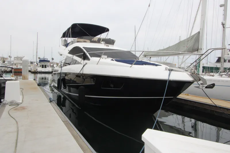 Slide: The Image of 2014 Sunseeker Manhattan 55 yacht docked at marina, front view. - 2