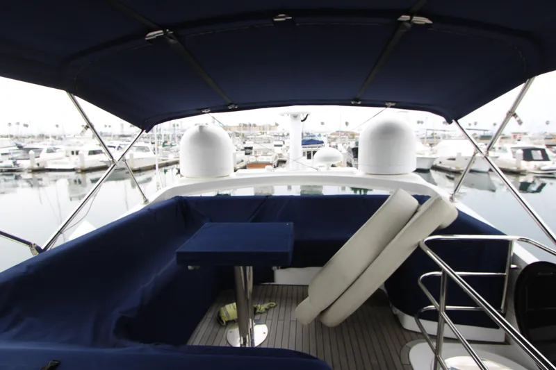 Slide: The Image of Sunseeker Manhattan 55 yacht interior, 2014 model, featuring a covered seating area in a marina. - 32