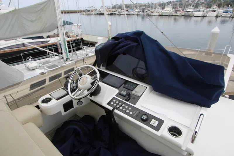 Slide: The Image of Helm of 2014 Sunseeker Manhattan 55 yacht at marina, featuring modern controls and steering wheel. - 34