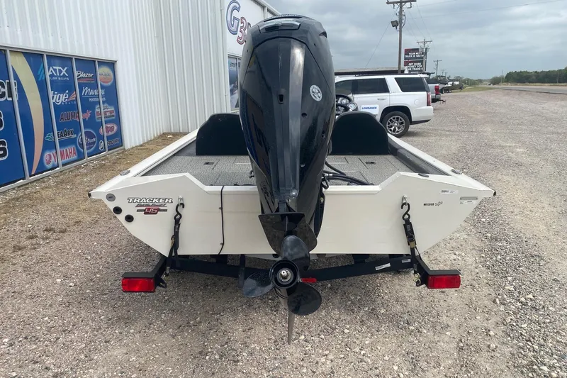 Slide: The Image of 2023 Tracker Pro Team 175 TF boat with outboard motor, parked on gravel. - 5