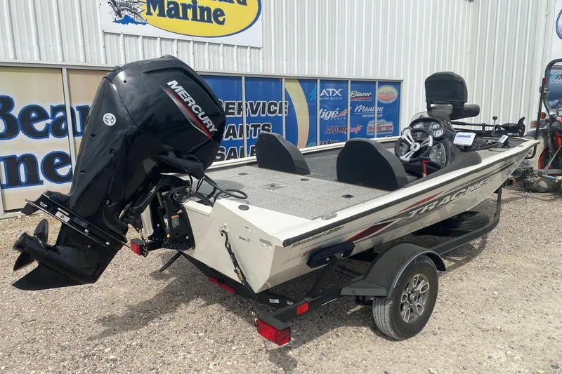 Slide: The Image of 2023 Tracker Pro Team 175 TF boat with Mercury engine, parked outside a marine store. - 6