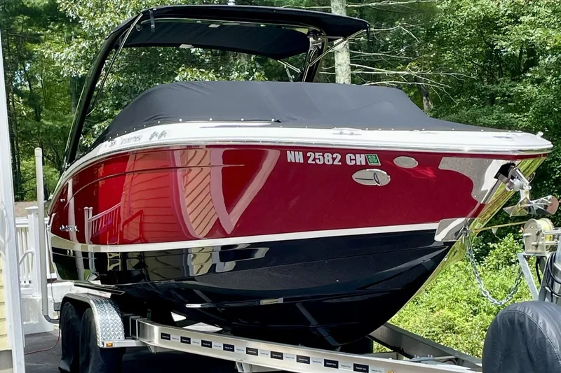 The Image of 2021 Regal LS6 boat on trailer, red and black, parked outdoors. - 0