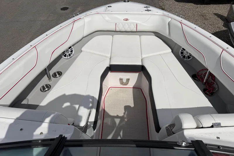 Slide: The Image of 2021 Regal LS6 boat interior with white seating, red accents, and cup holders. - 14