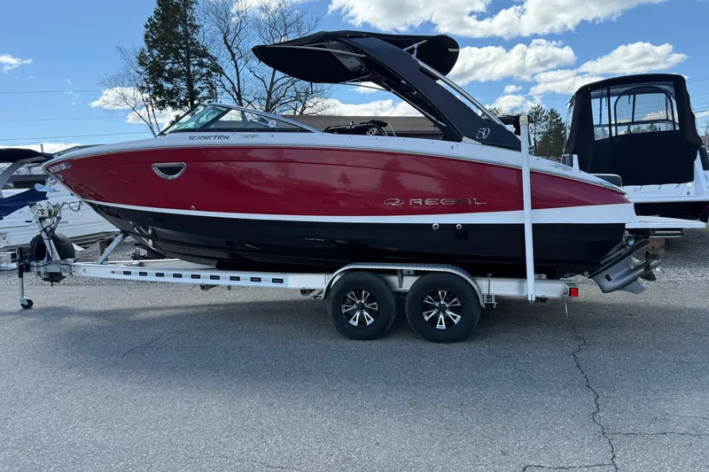 Slide: The Image of 2021 Regal LS6 boat on trailer, red and black design, parked outdoors. - 19