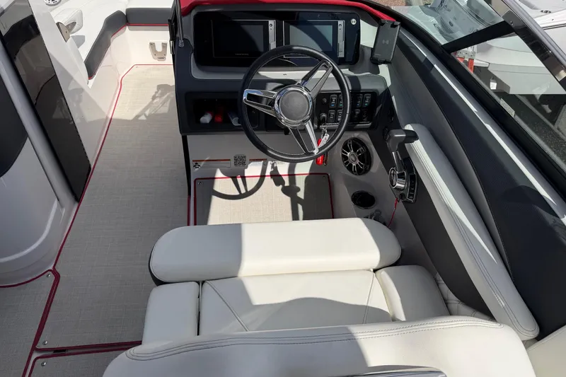 Slide: The Image of 2021 Regal LS6 boat cockpit with steering wheel, control panel, and white seating. - 22
