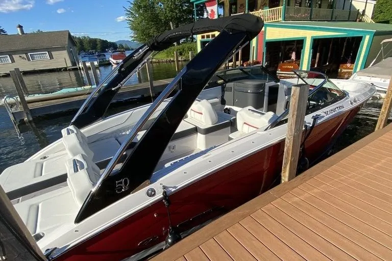 Slide: The Image of 2021 Regal LS6 boat docked by a lakeside, featuring sleek design and modern amenities. - 3