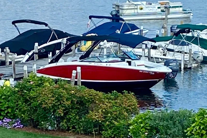 Slide: The Image of Red 2021 Regal LS6 boat docked at marina with lush greenery in foreground. - 6