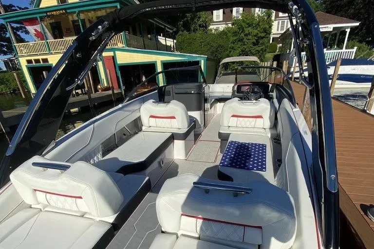 Slide: The Image of 2021 Regal LS6 boat interior with white seating and modern design near dock. - 7