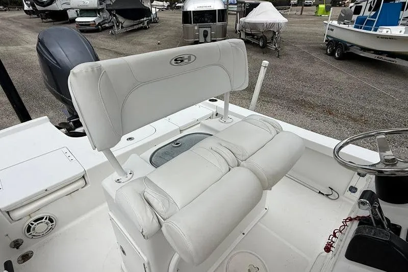 Slide: The Image of 2016 Sea Hunt BX 22 BR boat interior with white seating and steering wheel. - 17