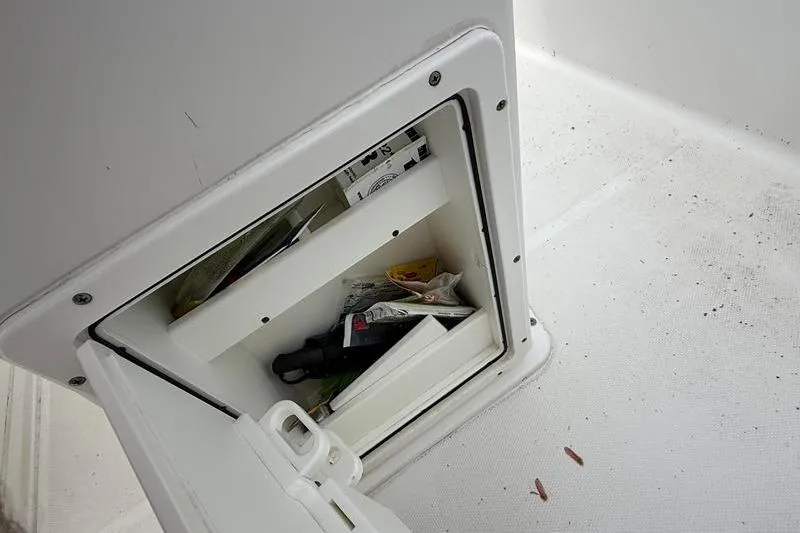 Slide: The Image of Storage compartment on a 2016 Sea Hunt BX 22 BR boat, containing various items. - 23