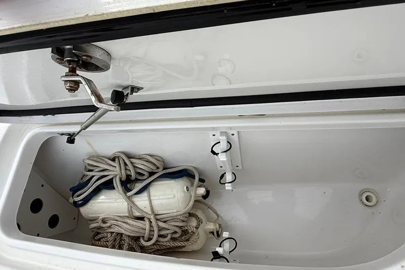 Slide: The Image of Open storage compartment in a 2016 Sea Hunt BX 22 BR boat with ropes and fender. - 32