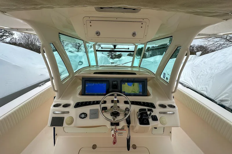 Slide: The Image of Helm of 2011 Grady-White Canyon 366 boat with navigation screens and steering wheel. - 13