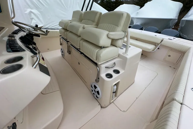 Slide: The Image of 2011 Grady-White Canyon 366 boat interior with cushioned seating and steering console. - 18