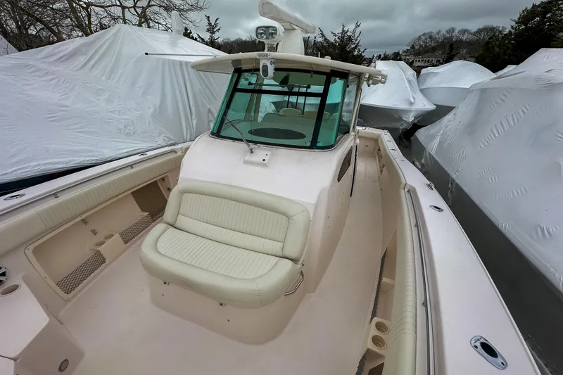 Slide: The Image of 2011 Grady-White Canyon 366 boat with covered seating, docked among wrapped vessels. - 23