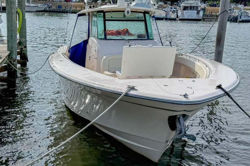 Slide: The Image of 2011 Grady-White Canyon 366 boat docked in a marina, showcasing sleek design and spacious deck. - 3
