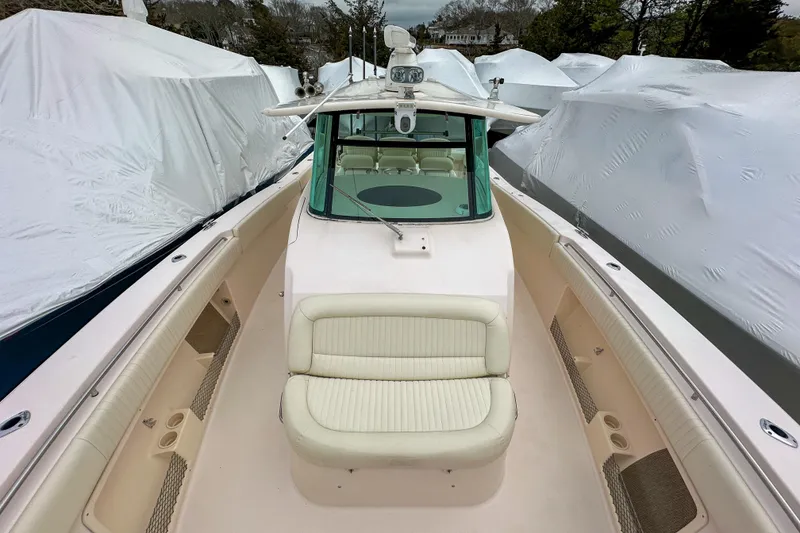 Slide: The Image of 2011 Grady-White Canyon 366 boat with cushioned seating, docked among covered vessels. - 31