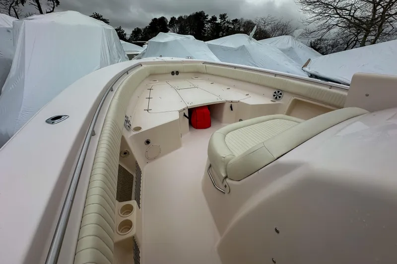 Slide: The Image of 2011 Grady-White Canyon 366 boat interior with seating and storage, covered in winter tarps. - 32