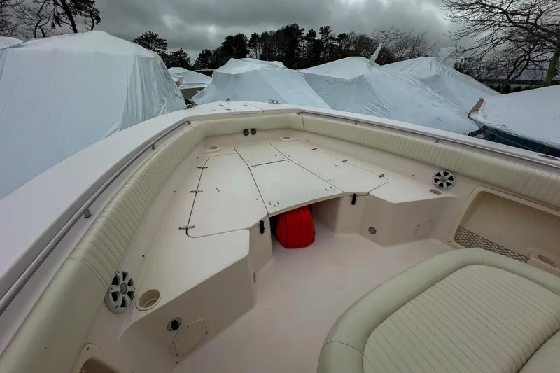 Slide: The Image of 2011 Grady-White Canyon 366 boat interior with seating and storage, under cloudy skies. - 34