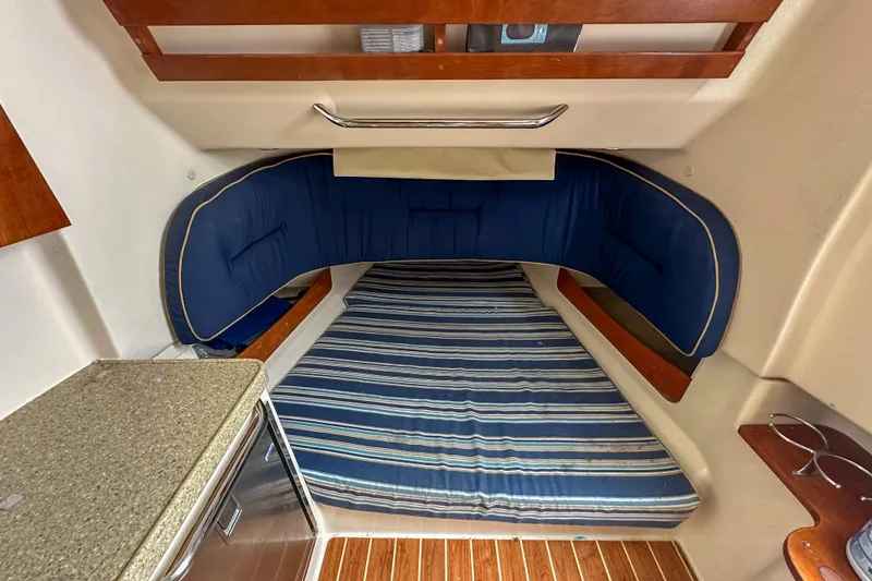 Slide: The Image of 2011 Grady-White Canyon 366 cabin interior with striped bedding and blue cushions. - 50