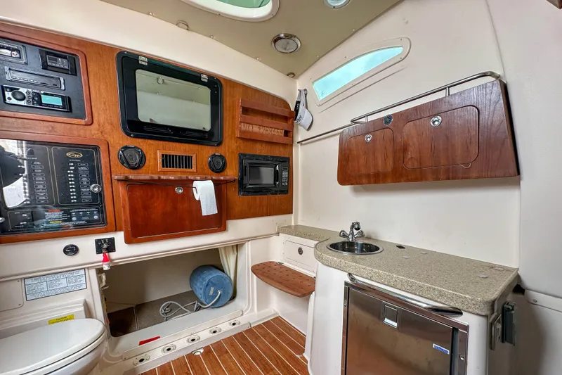Slide: The Image of Interior of 2011 Grady-White Canyon 366 boat with kitchenette and control panel. - 52