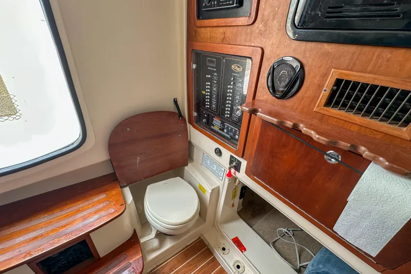 Slide: The Image of Interior of 2011 Grady-White Canyon 366 boat featuring control panel and compact toilet. - 53