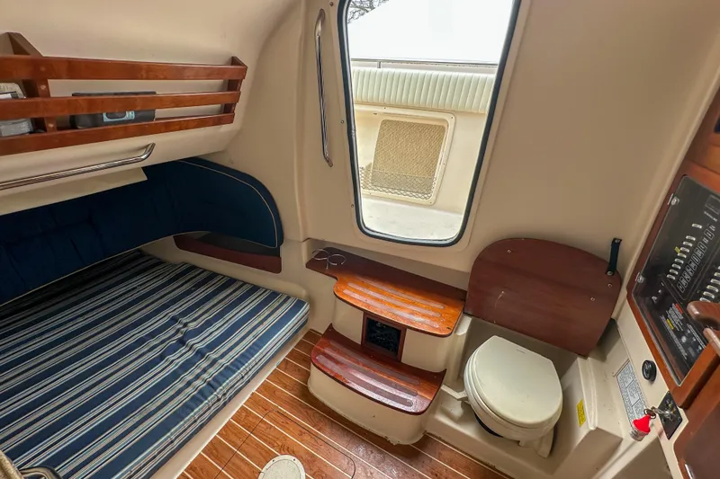 Slide: The Image of 2011 Grady-White Canyon 366 cabin interior with bed, toilet, and wooden accents. - 55