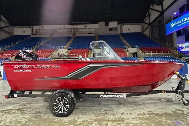 The Image of 2026 Crestliner 1750 Bass Hawk boat in red, displayed indoors on a trailer. - 1