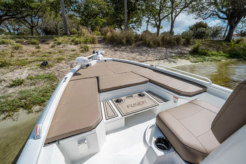 Slide: The Image of Avid 23 Fusion 2026 boat with cushioned seating by the shore. - 15