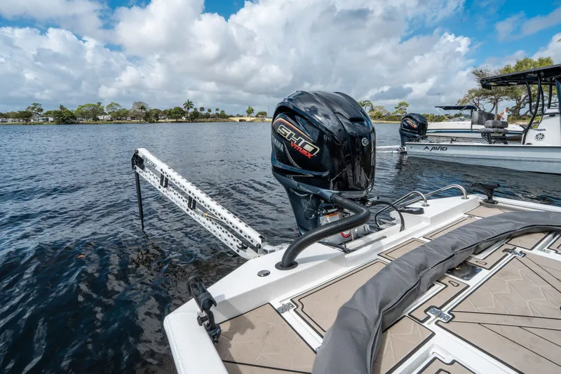 Slide: The Image of Avid 23 Fusion 2026 boat on calm water with outboard motor. - 21