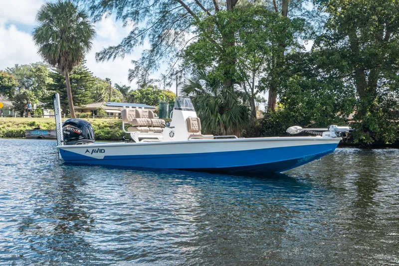Slide: The Image of Avid 23 Fusion 2026 boat on calm water, surrounded by trees. - 4