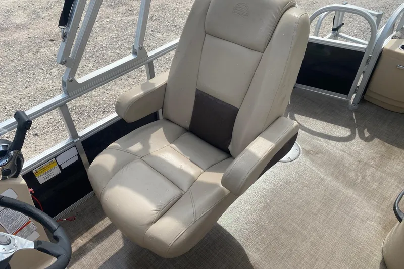 Slide: The Image of 2018 Sun Tracker Fishin' Barge 20 DLX captain's chair, beige upholstery, on boat deck. - 11