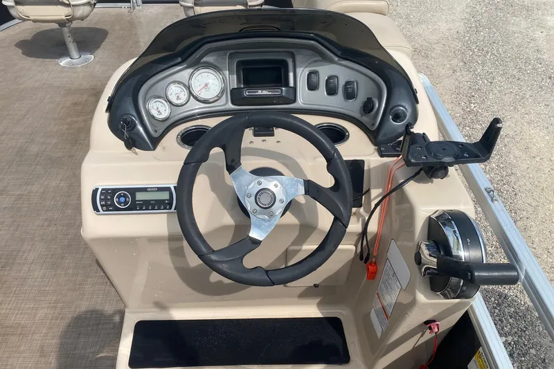 Slide: The Image of 2018 Sun Tracker Fishin' Barge 20 DLX dashboard with steering wheel and control panel. - 13