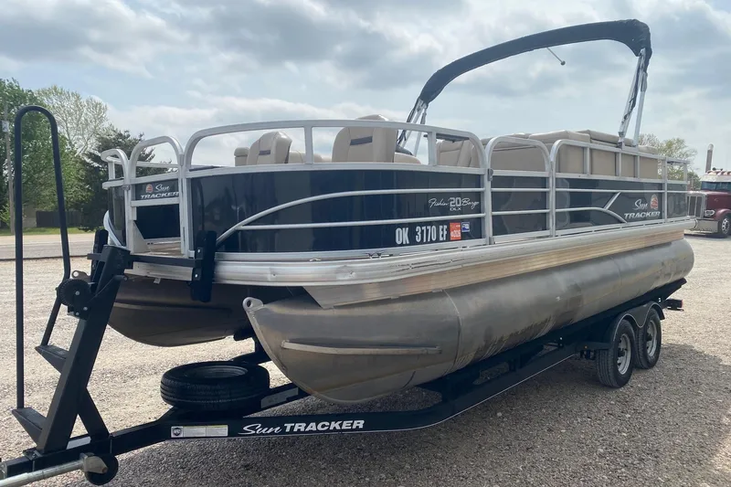 Slide: The Image of 2018 Sun Tracker Fishin' Barge 20 DLX pontoon boat on trailer, parked outdoors. - 3