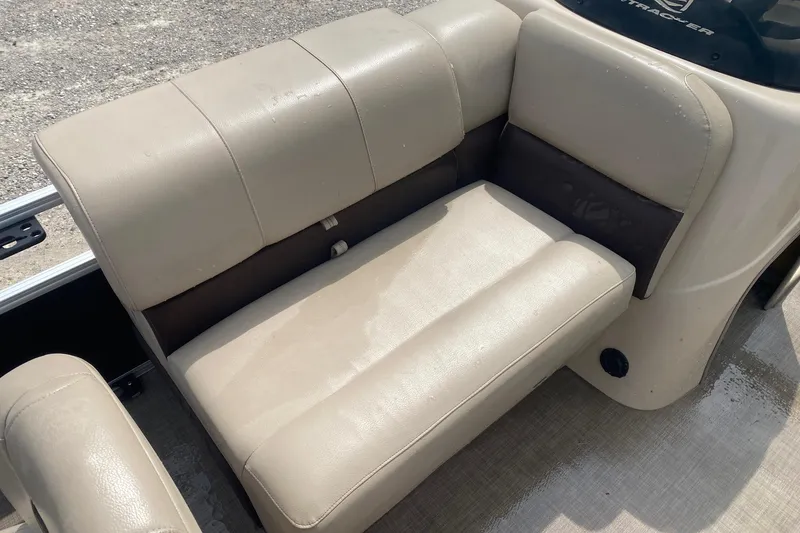 Slide: The Image of 2018 Sun Tracker Fishin' Barge 20 DLX beige seating, wet surface, outdoor setting. - 9