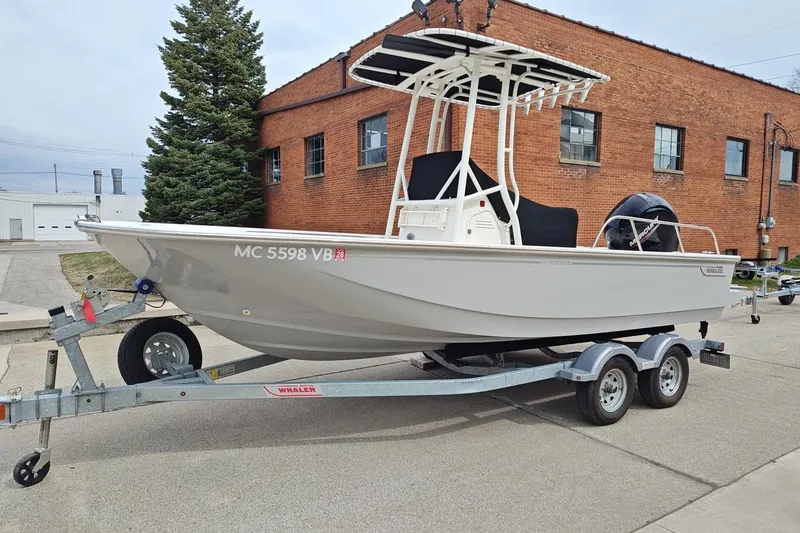 The Image of 2025 Boston Whaler 190 Montauk boat on trailer, parked near a brick building. - 1