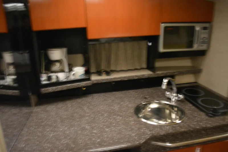 Slide: The Image of 2004 Formula 31 Performance Cruiser kitchen with sink, stove, microwave, and coffee maker. - 15