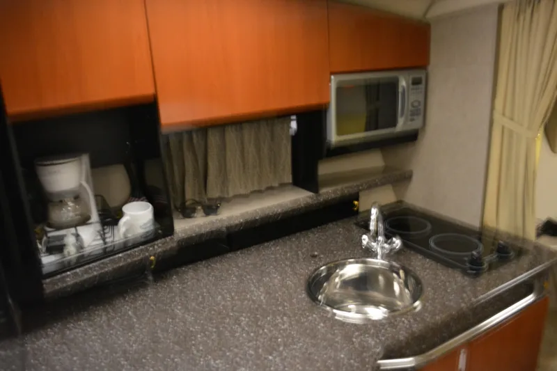 Slide: The Image of 2004 Formula 31 Performance Cruiser kitchen with sink, stove, microwave, and coffee maker. - 17