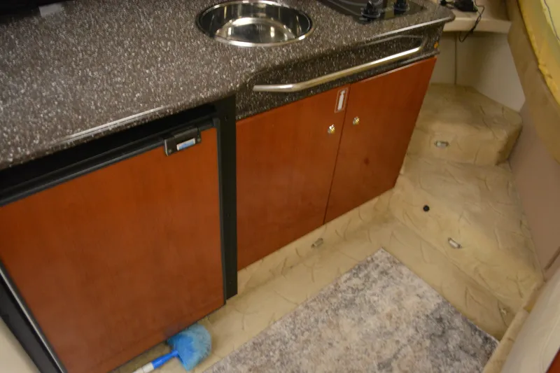 Slide: The Image of 2004 Formula 31 Performance Cruiser interior kitchen with sink and wooden cabinets. - 18