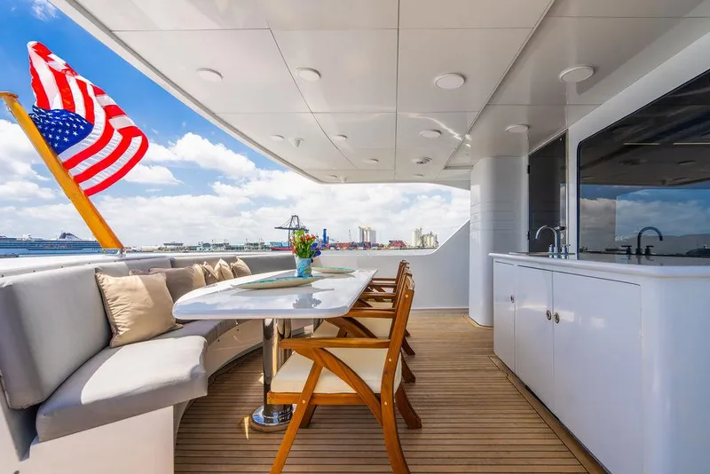 Slide: The Image of Outdoor deck of a 2001 Intermarine Raised Pilothouse yacht with seating and American flag. - 4