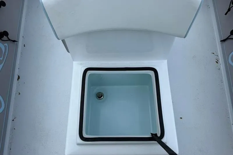 Slide: The Image of Livewell compartment on 2025 Cayo Boatworks 180, featuring a clean, white interior. - 15