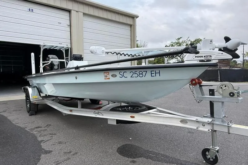 Slide: The Image of 2025 Cayo Boatworks 180 on trailer, parked outside a garage. - 6