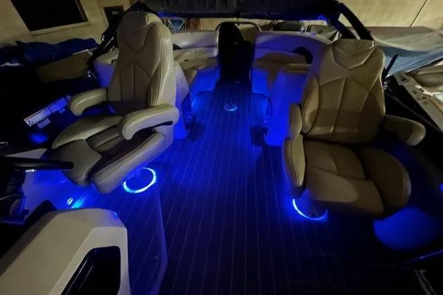 Slide: The Image of 2020 Manitou Oasis 250 interior with blue LED lighting and luxurious seating. - 12