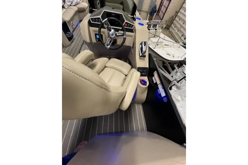 Slide: The Image of Interior view of 2020 Manitou Oasis 250 boat with beige seating and modern dashboard. - 6
